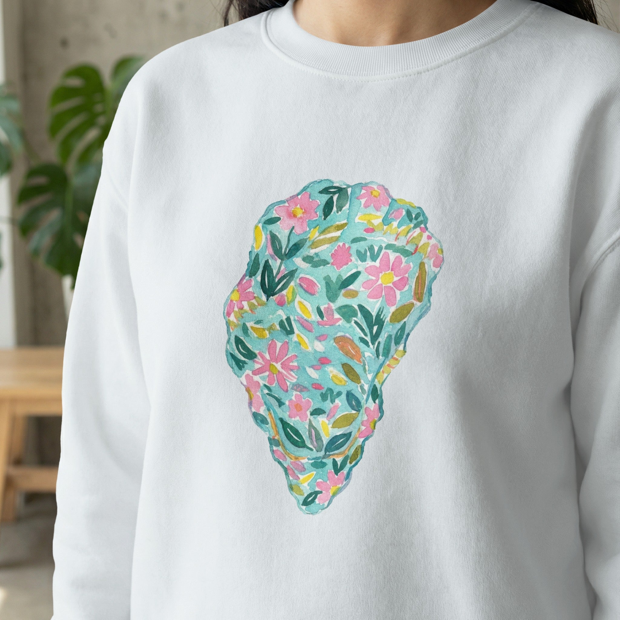 White sweatshirt with a colorful watercolor floral oyster shell design.