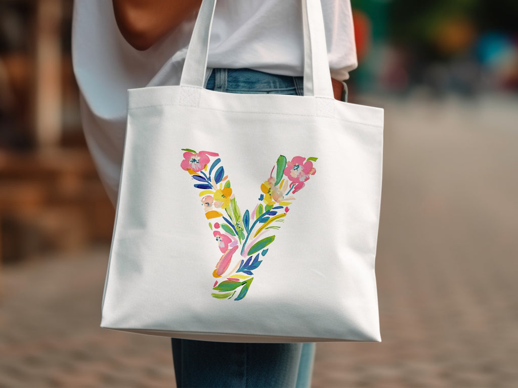 White tote bag with a colorful floral letter V design.