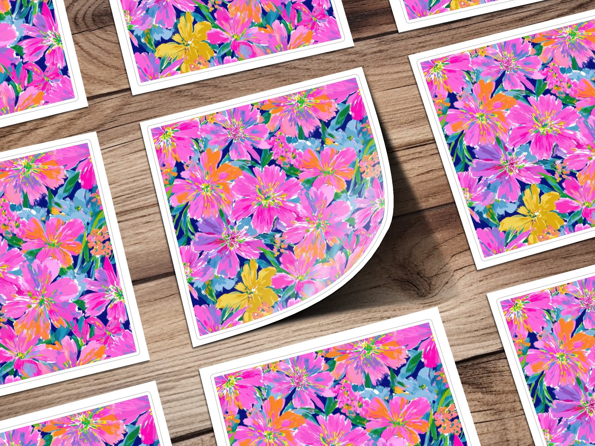 Floral pattern cards with pink, yellow, and blue flowers on a wooden surface.