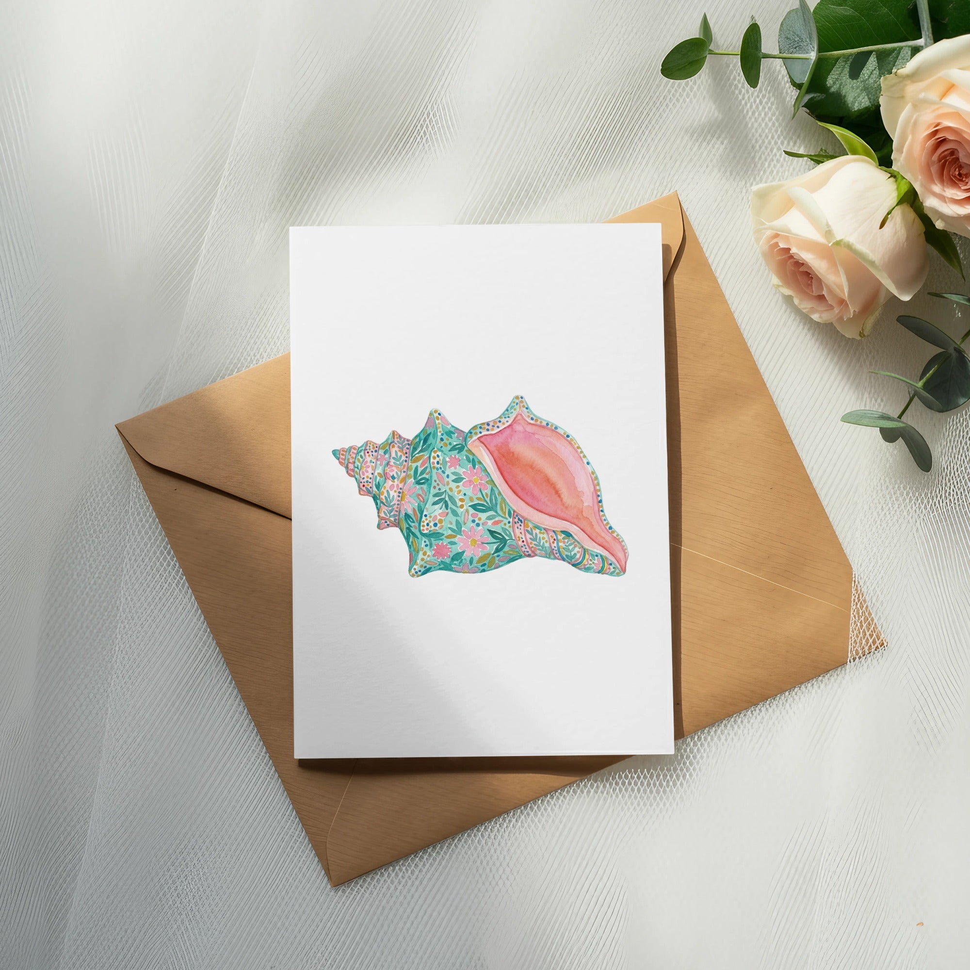 Watercolor seashell with floral pattern on card, over a kraft envelope.
