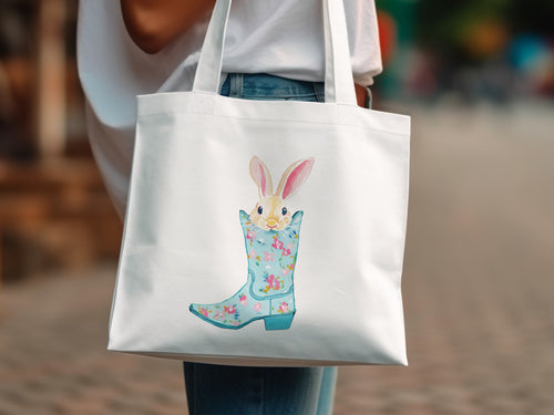 Bunny peeking from a floral blue cowboy boot on a white tote bag.