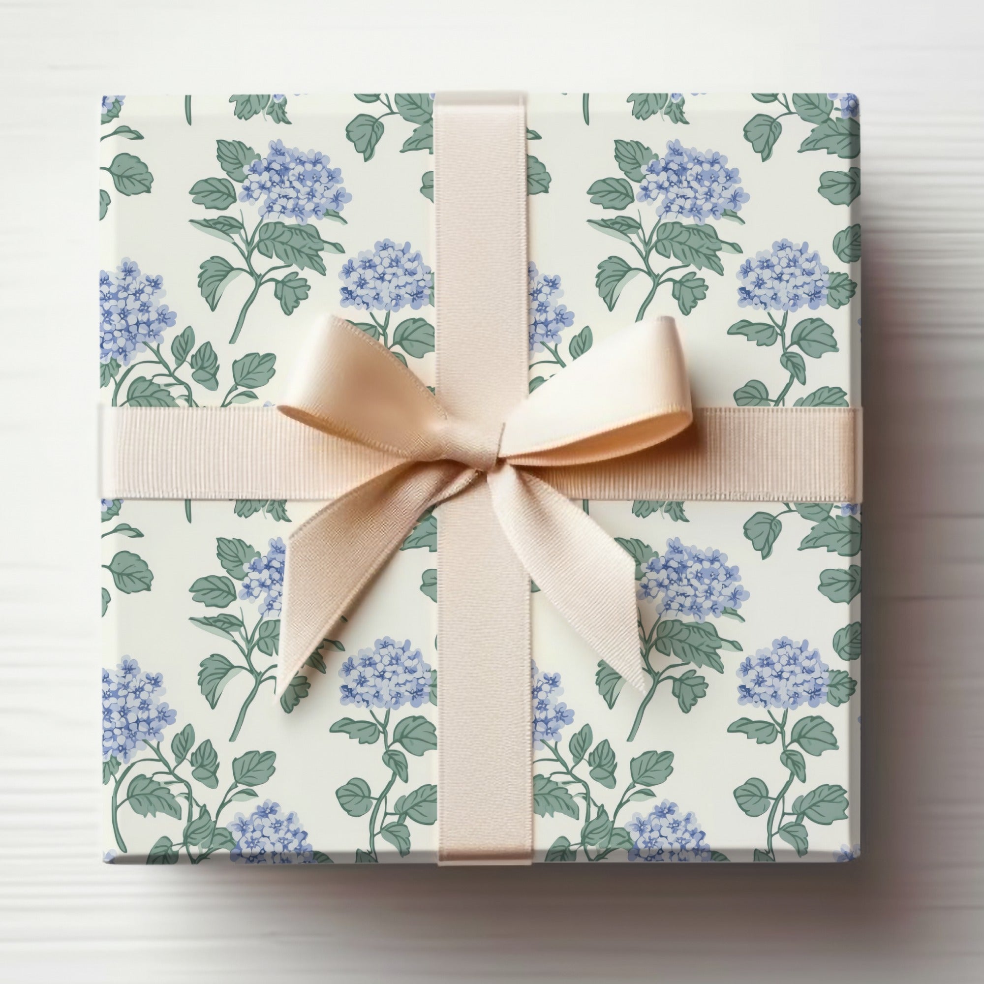 Gift-wrapped box with floral pattern and light beige ribbon bow.
