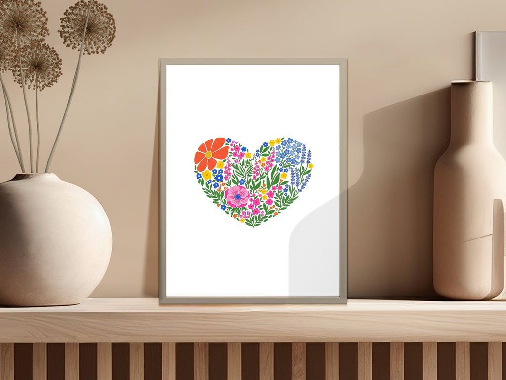 Heart-shaped floral arrangement with colorful flowers on a light gray background.