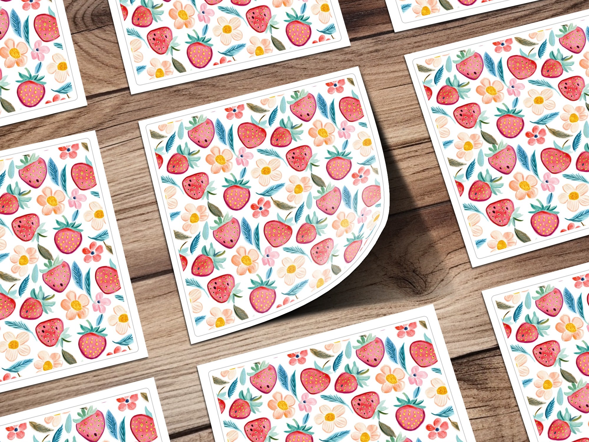 Scattered small cards with repeating strawberry and floral pattern.