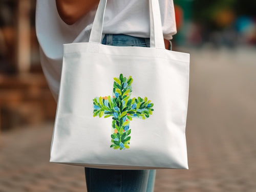 White canvas tote bag with a green and blue floral cross design.
