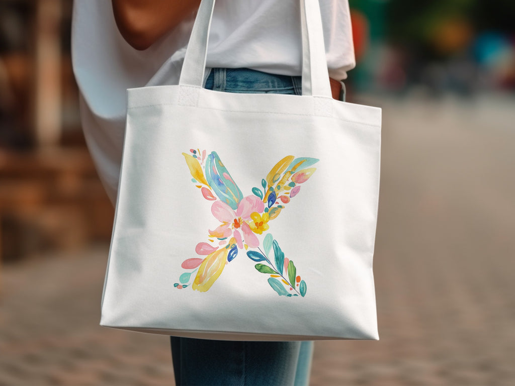 White tote bag with a colorful floral letter X design.