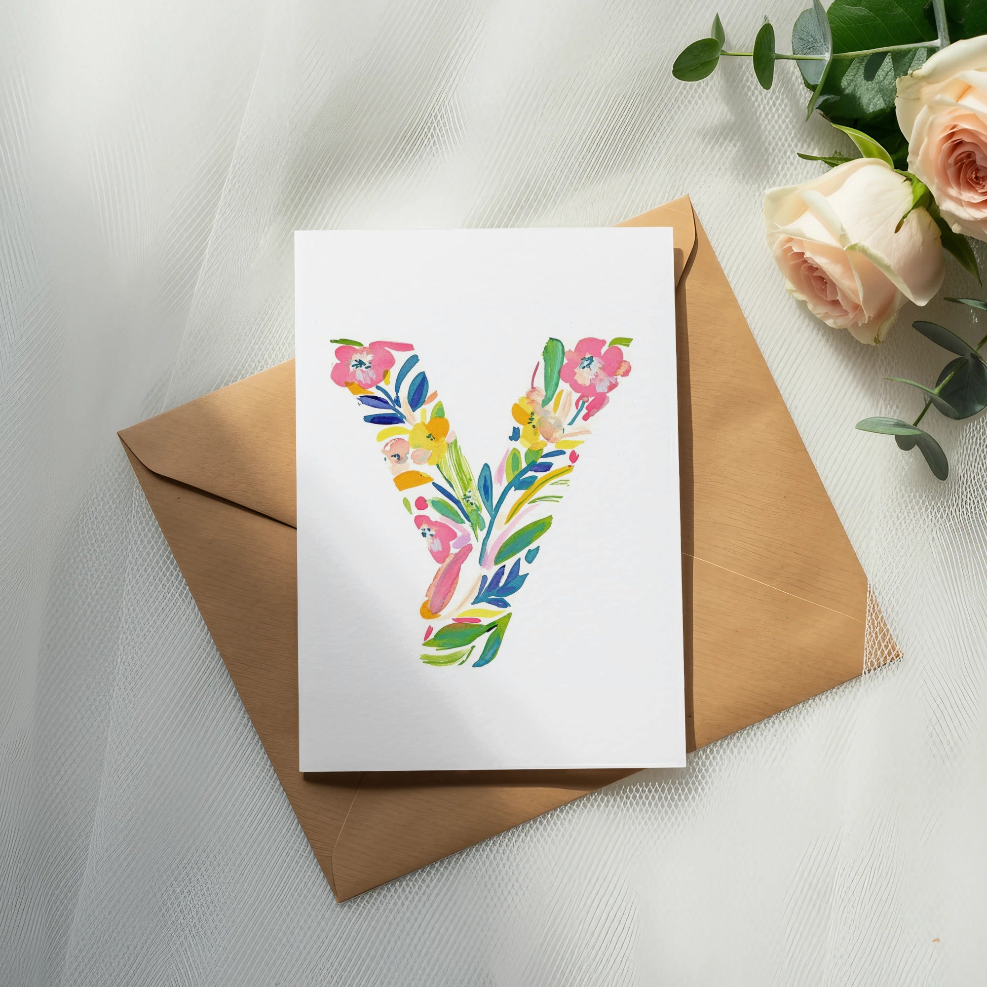 White card with colorful floral letter "Y" on brown envelope.