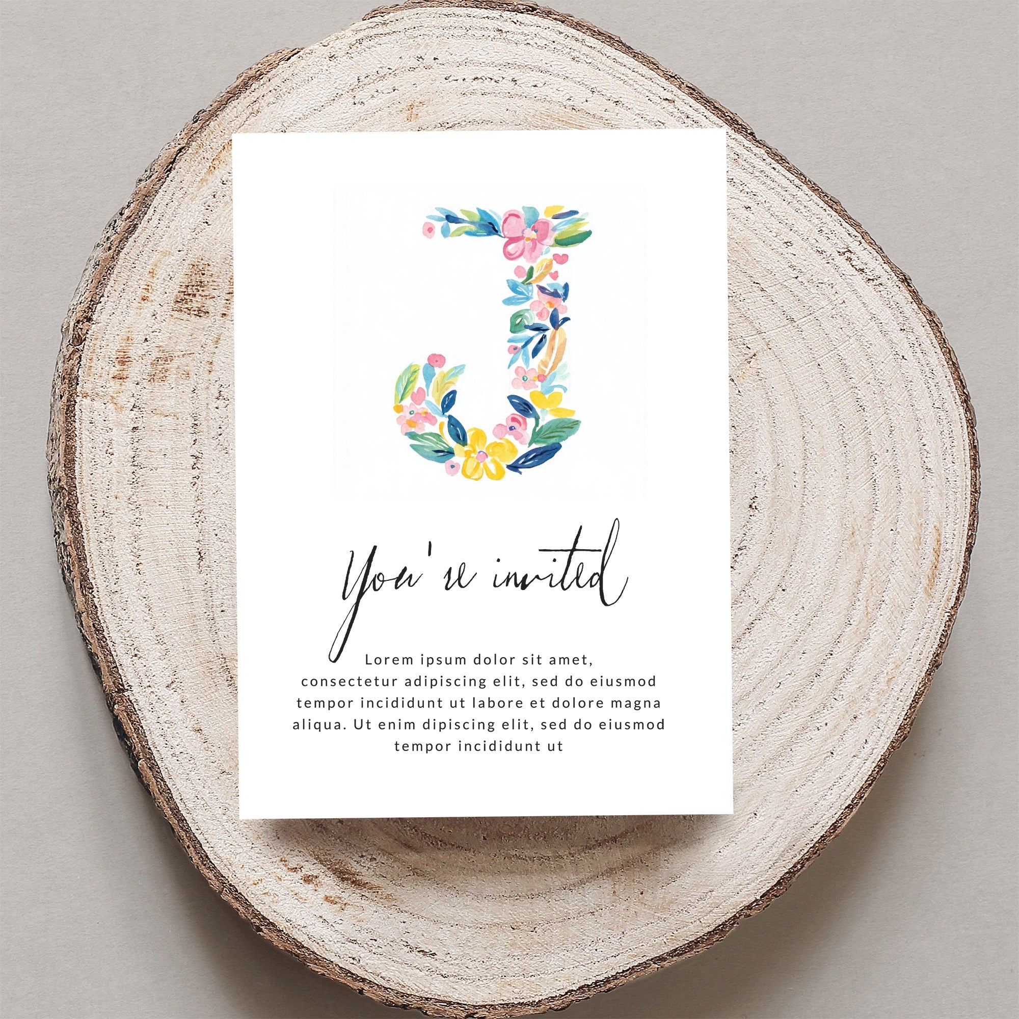 Floral letter J on invitation with "You're invited" text.