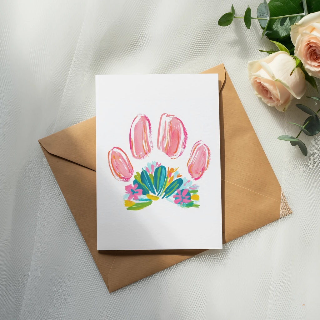 Card with pink paw print and floral design on brown envelope.