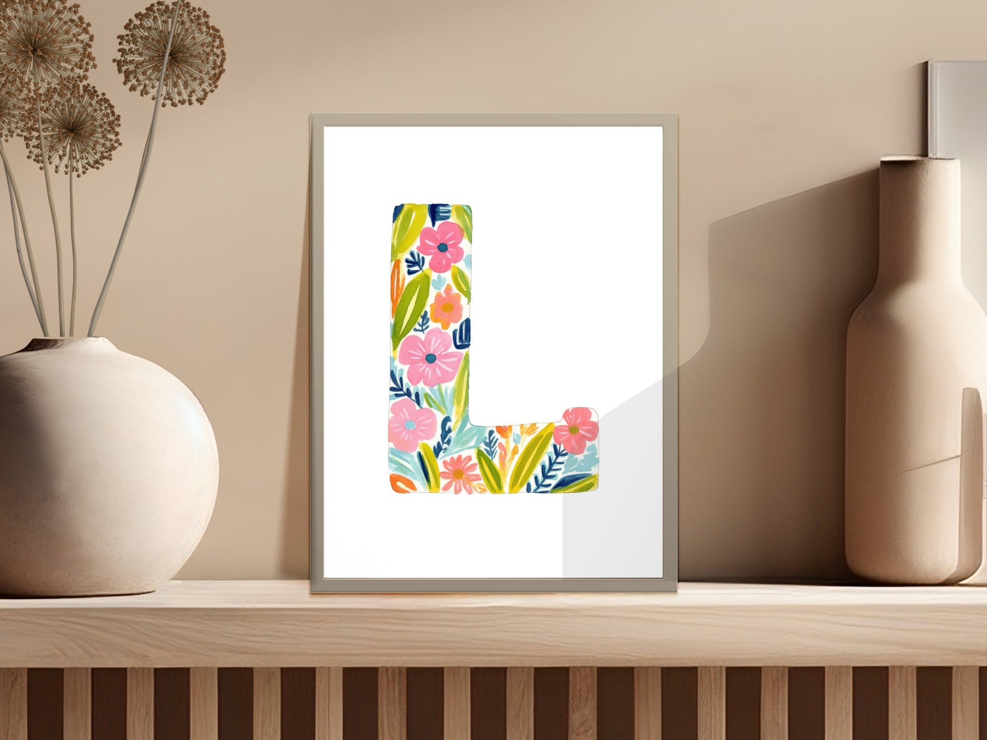 Letter L art print with colorful floral illustrations on a wooden shelf.