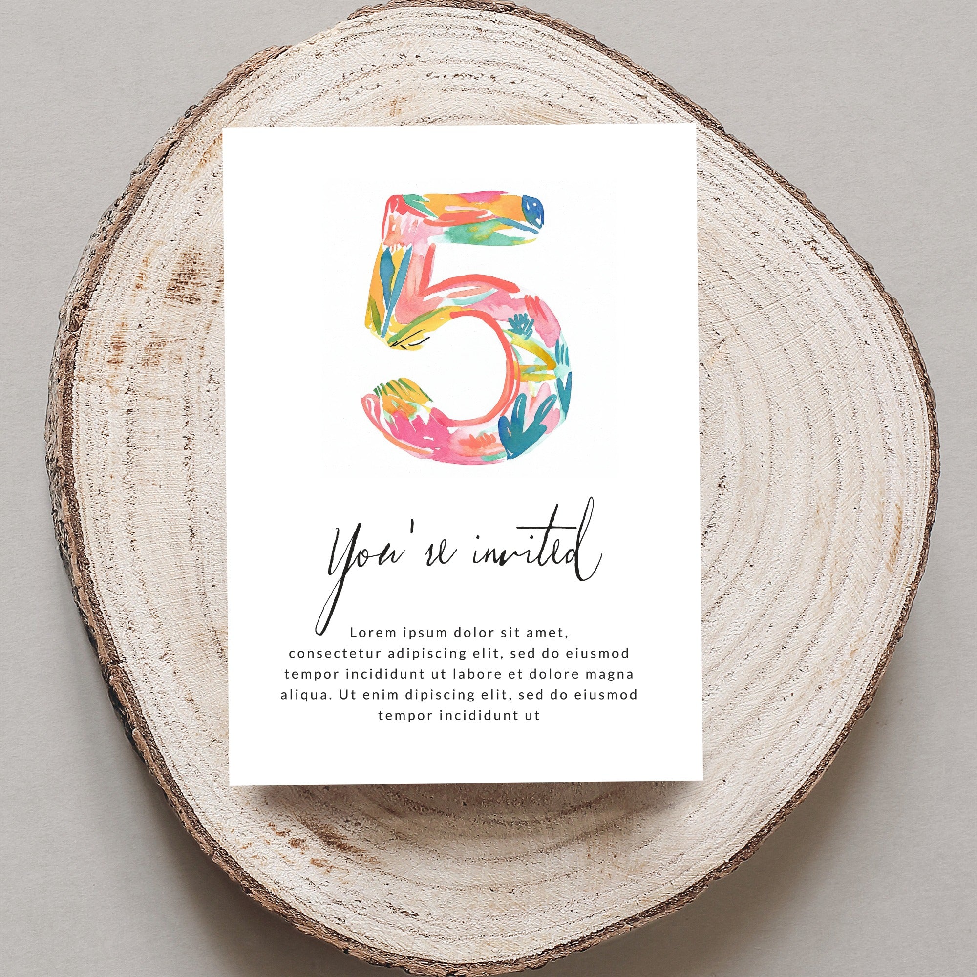 Card with "5" and "You're invited" text on wood slice.