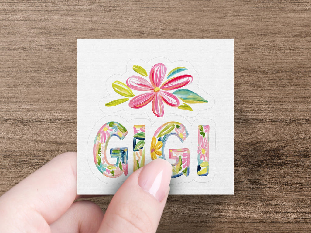 Gigi text with floral accents held by a hand.