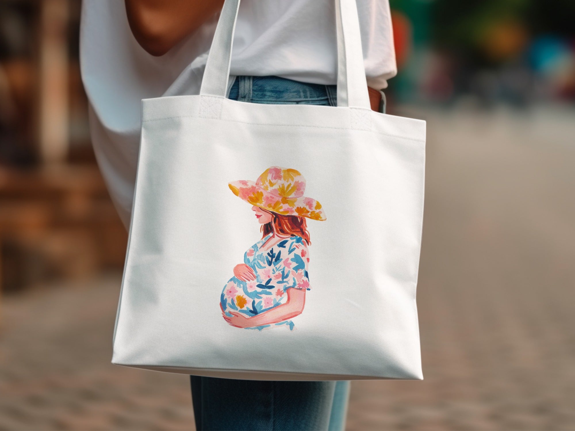 Tote bag with watercolor illustration of pregnant woman wearing floral hat and dress.