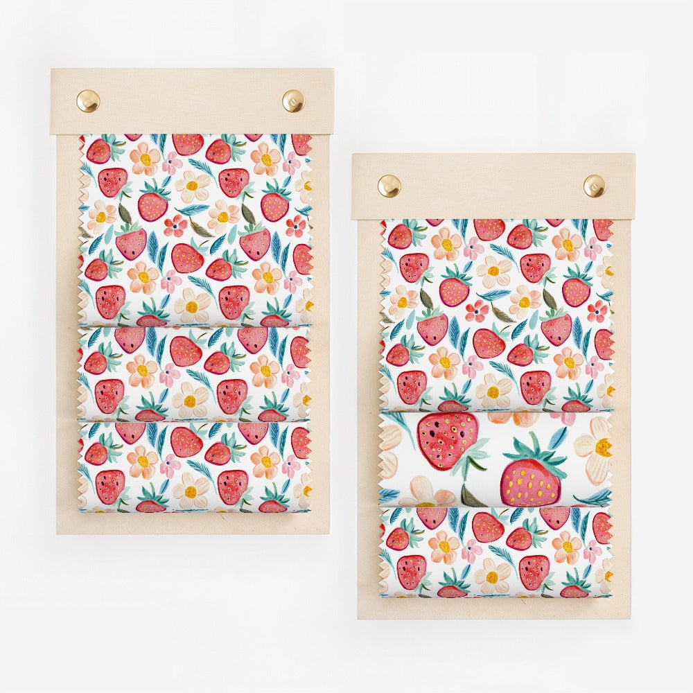 Swatches of fabric with a strawberry and floral pattern.