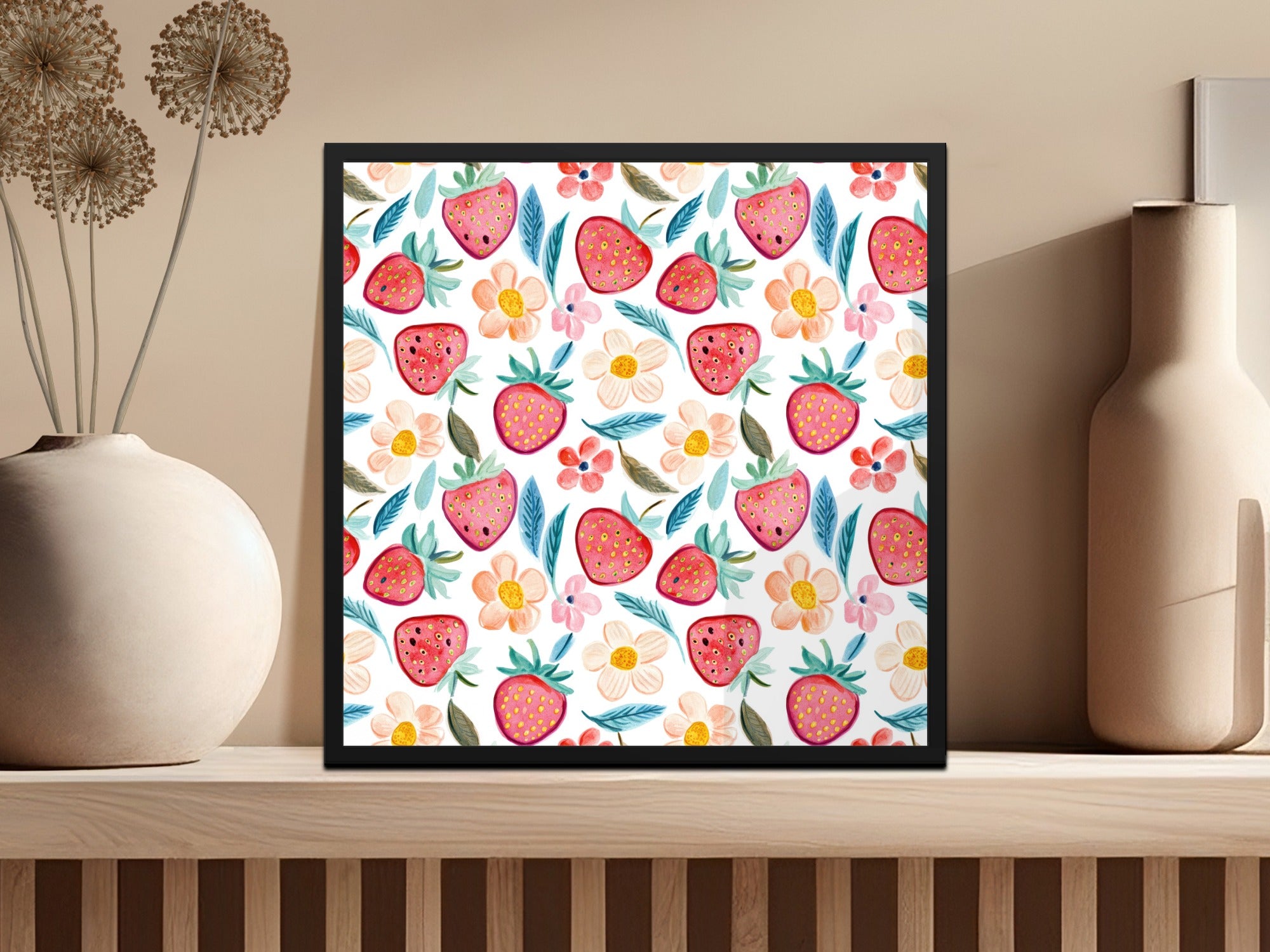 Framed artwork with strawberry and floral pattern on a shelf.