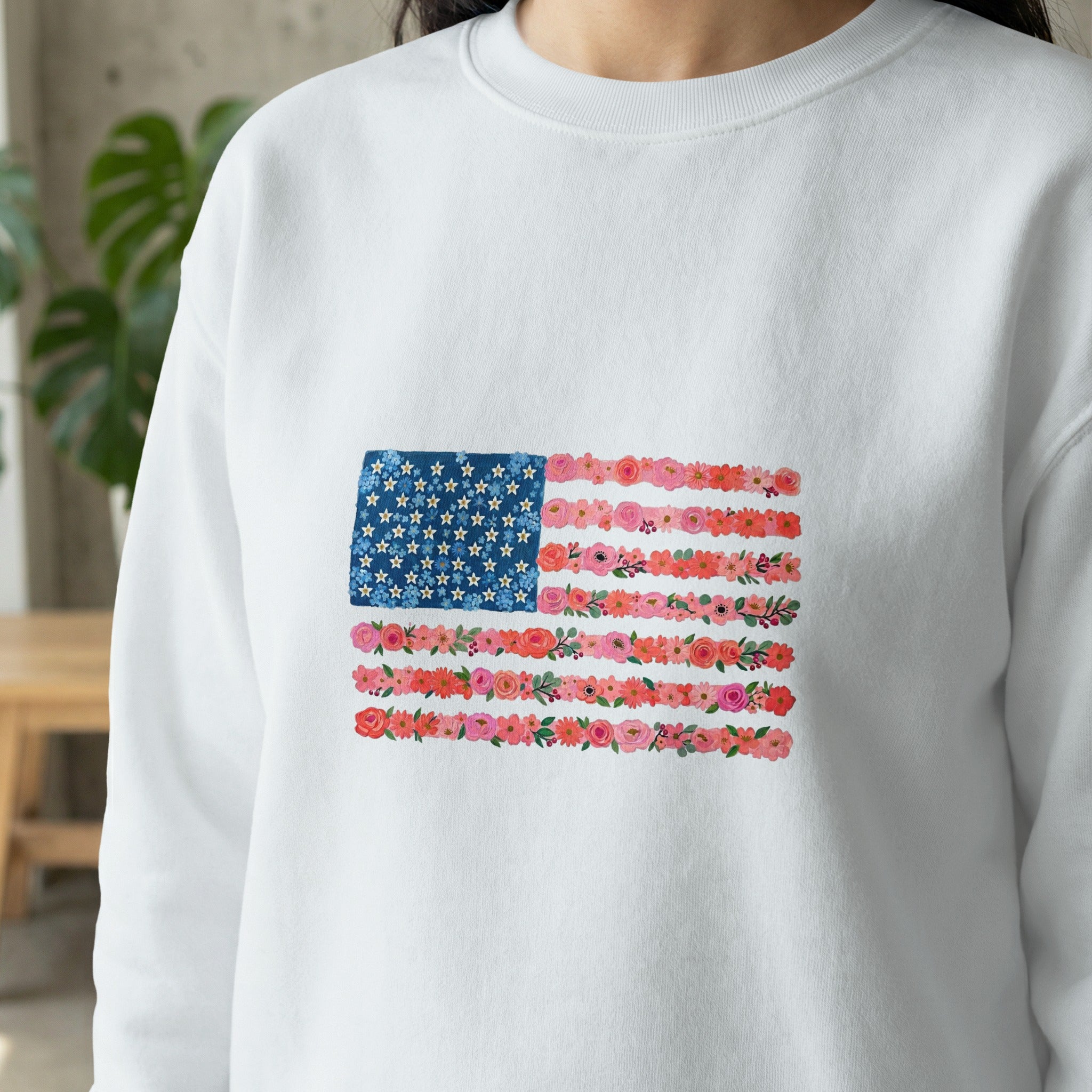 White sweatshirt with an American flag design made of flowers.