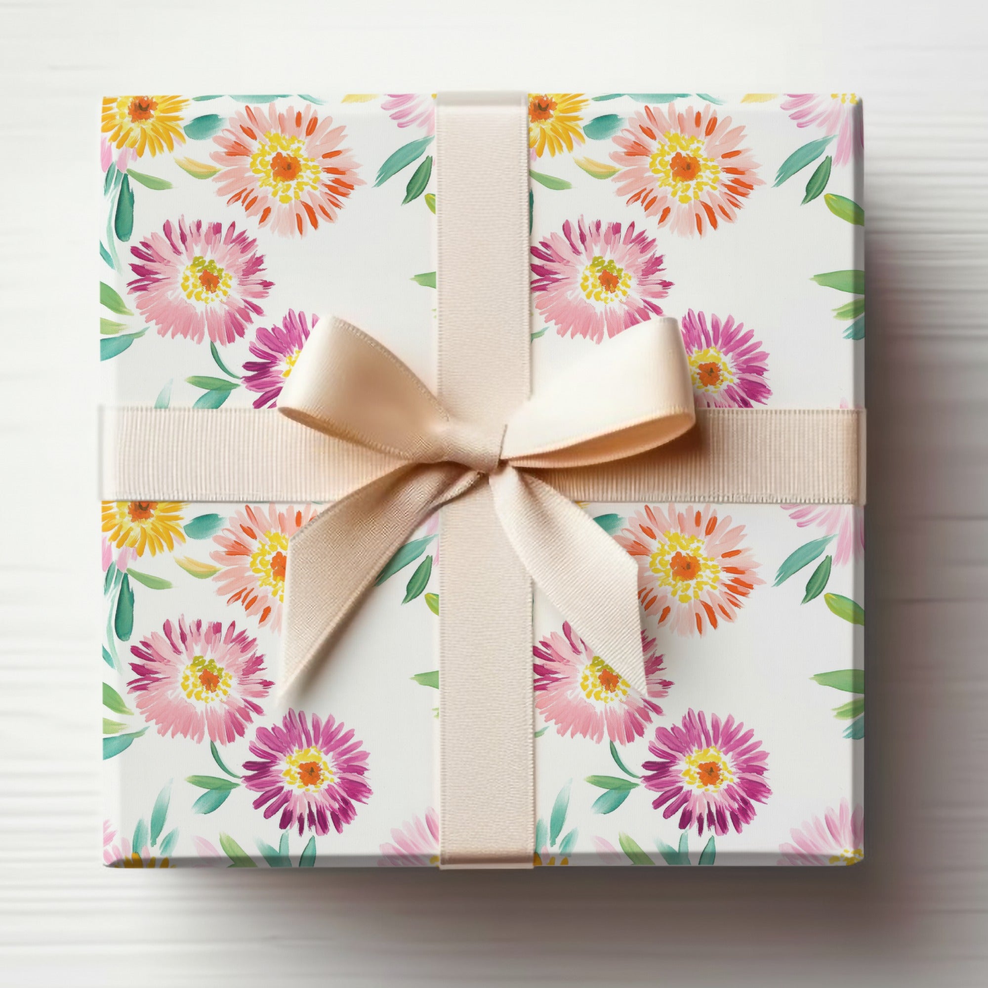 Gift-wrapped box with watercolor floral pattern and a beige ribbon bow.