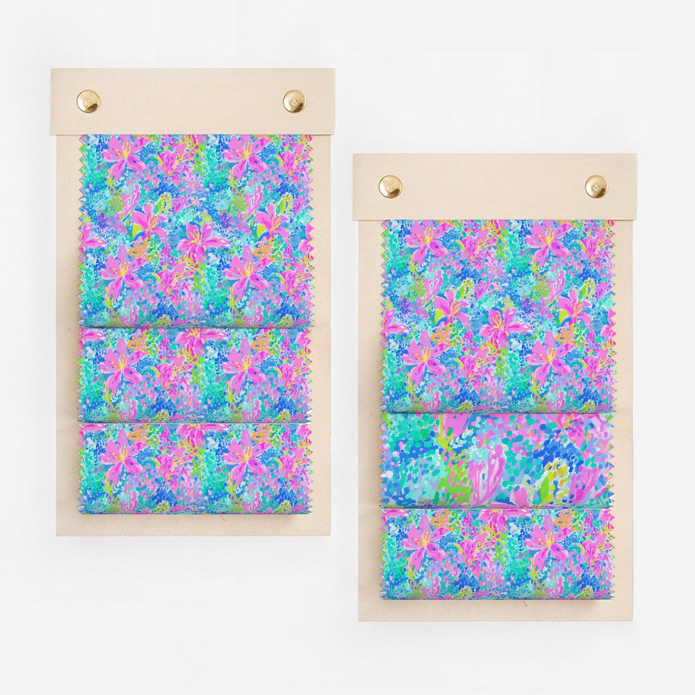 Two fabric swatches with vibrant floral pattern in pink, blue, and green.