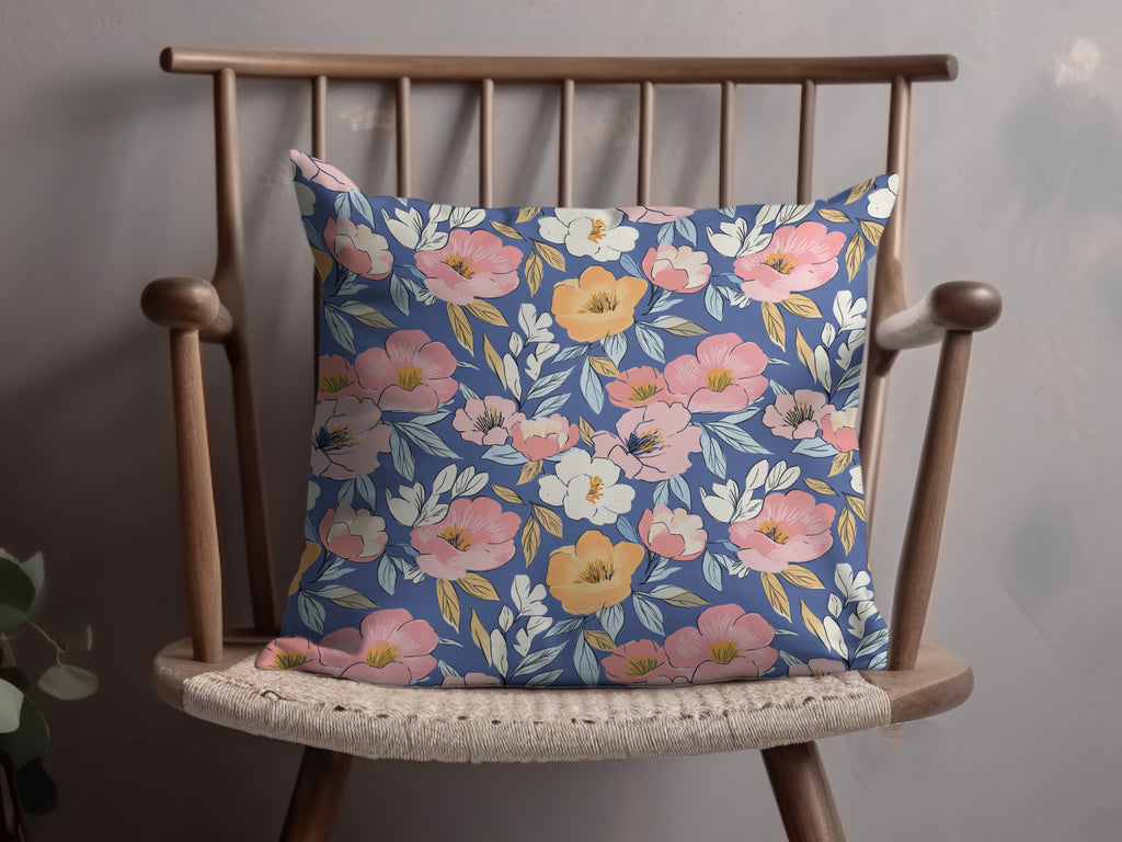 Blue decorative pillow with a floral pattern of pink and orange flowers.