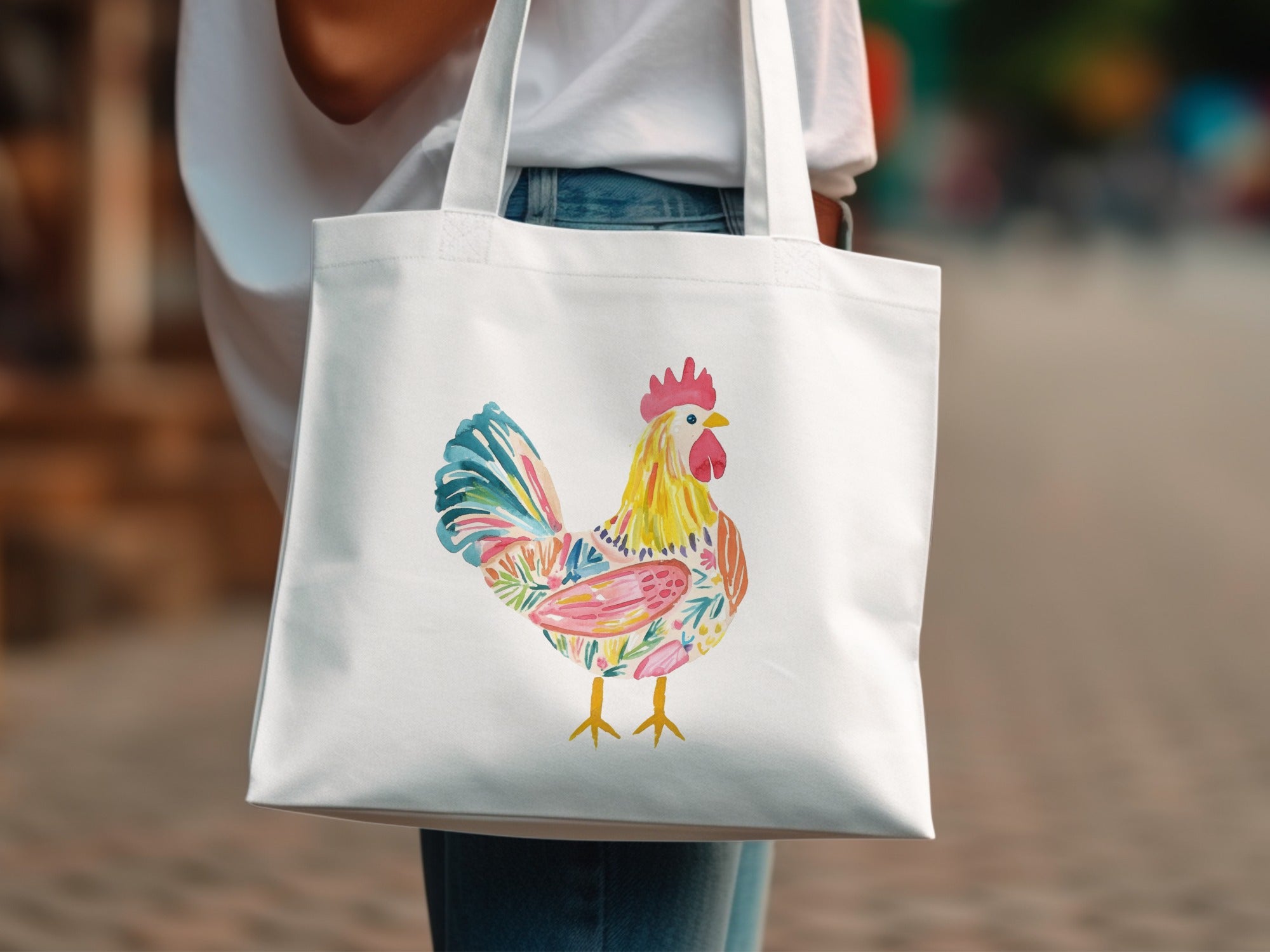 White tote bag with a colorful floral rooster illustration.