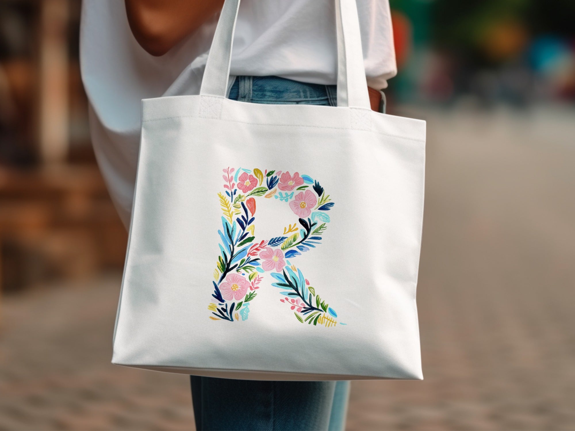 White canvas tote bag with a large floral letter R design.
