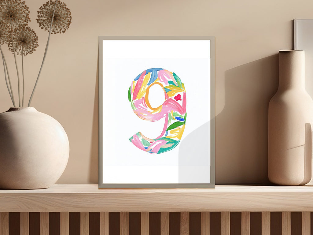 Colorful number 9 artwork with floral and leaf elements in a framed print.