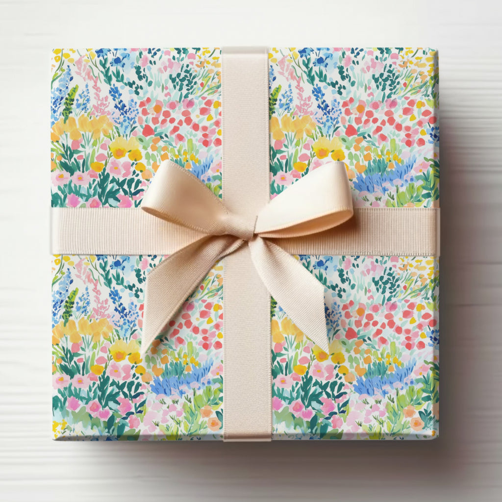Wrapped gift box with colorful floral pattern and cream ribbon bow.