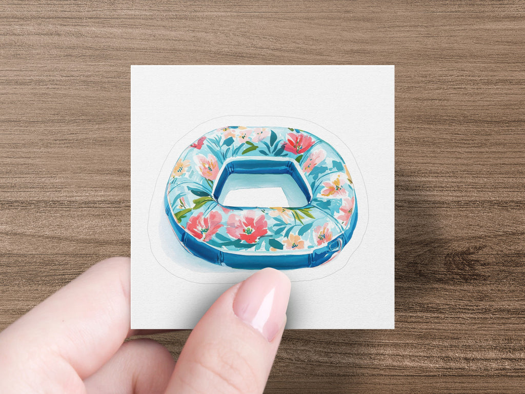 Blue inflatable pool float with a floral pattern held by a hand.