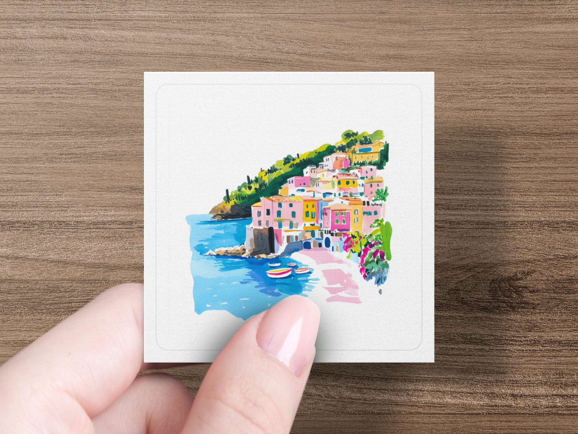 Watercolor painting of a colorful coastal Italian village with boats.