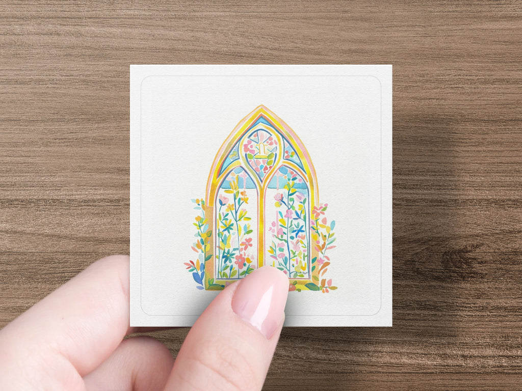 Watercolor illustration of a gothic window with floral decorations.