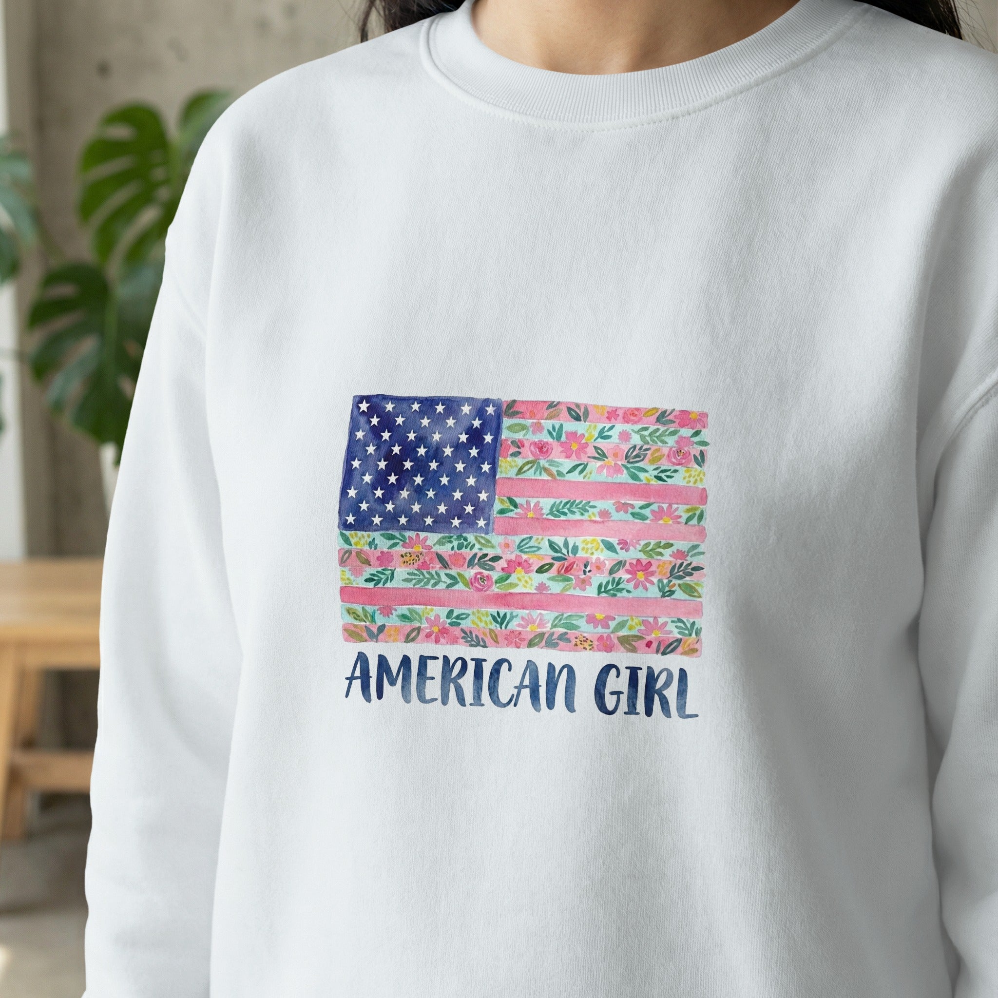 White sweatshirt with floral American flag and "AMERICAN GIRL" text.