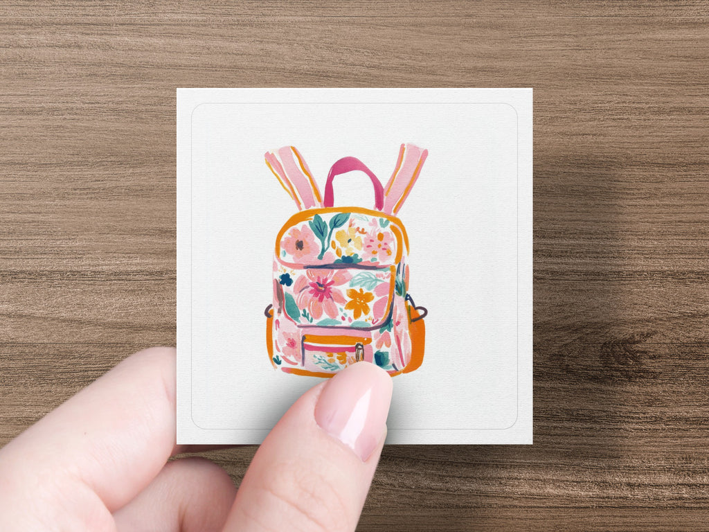 Floral print backpack with pink straps and orange pocket.