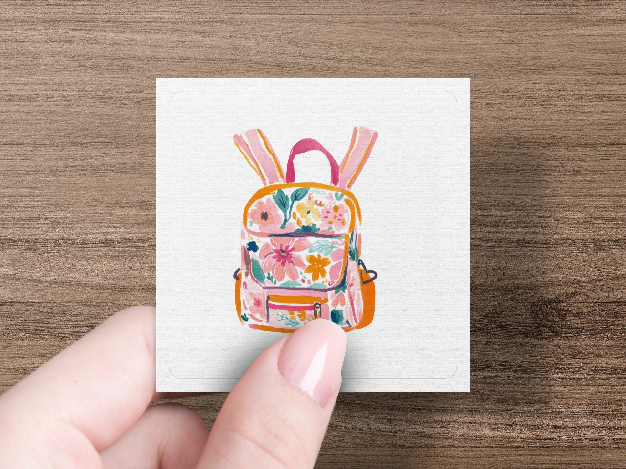 Floral print backpack with pink straps and orange pocket.