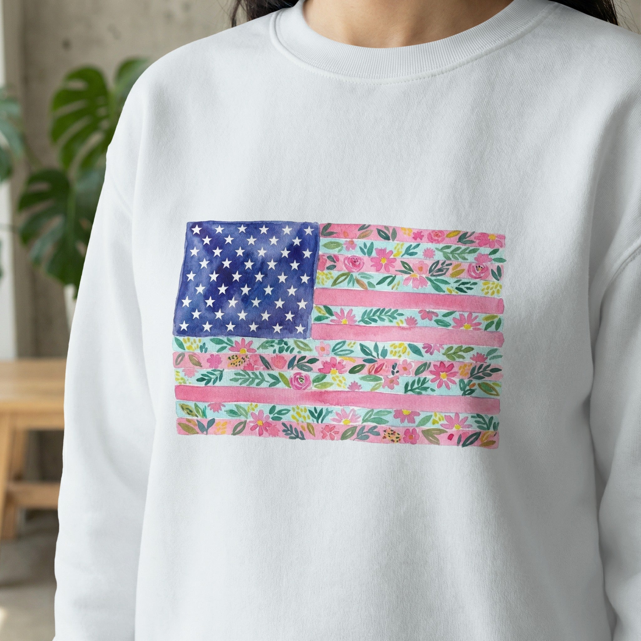White sweatshirt with a watercolor American flag design of flowers.