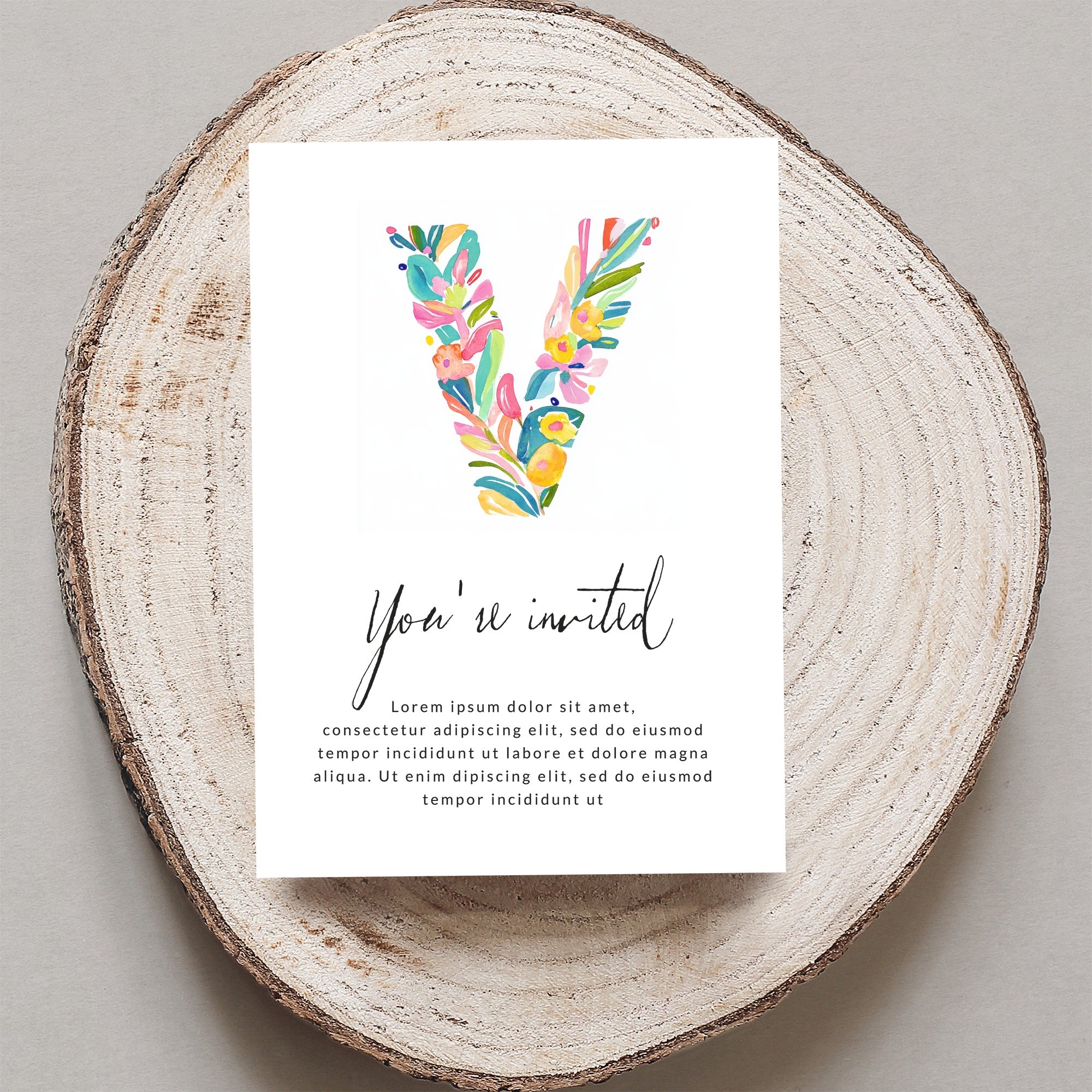 Invitation with colorful floral letter V and "You're invited" text.