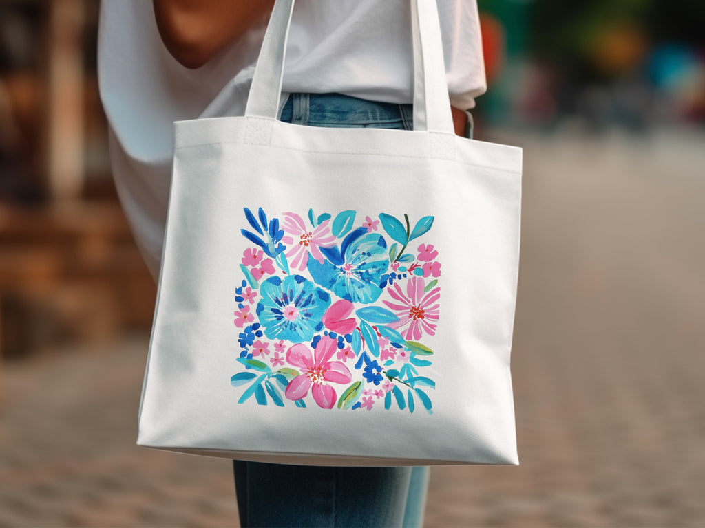 White tote bag with a vibrant floral watercolor print in pink and blue.