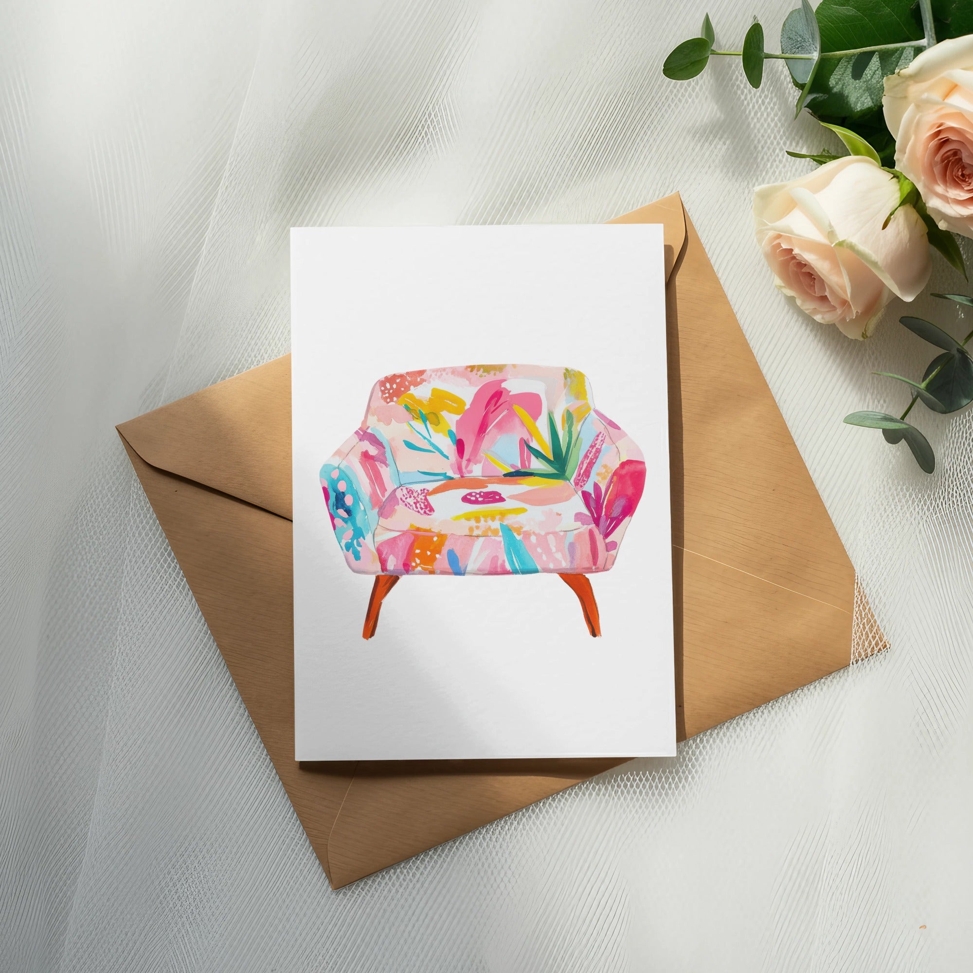 Watercolor illustration of a floral armchair on a card, atop an envelope.