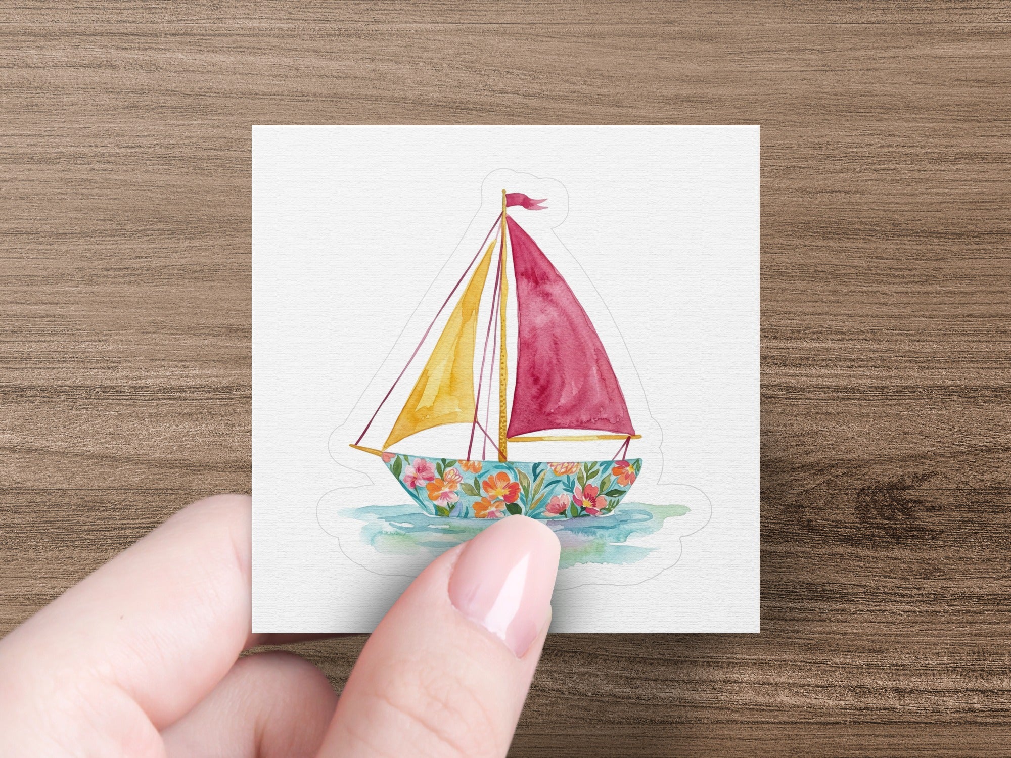 Sailboat with red and yellow sails on floral water.