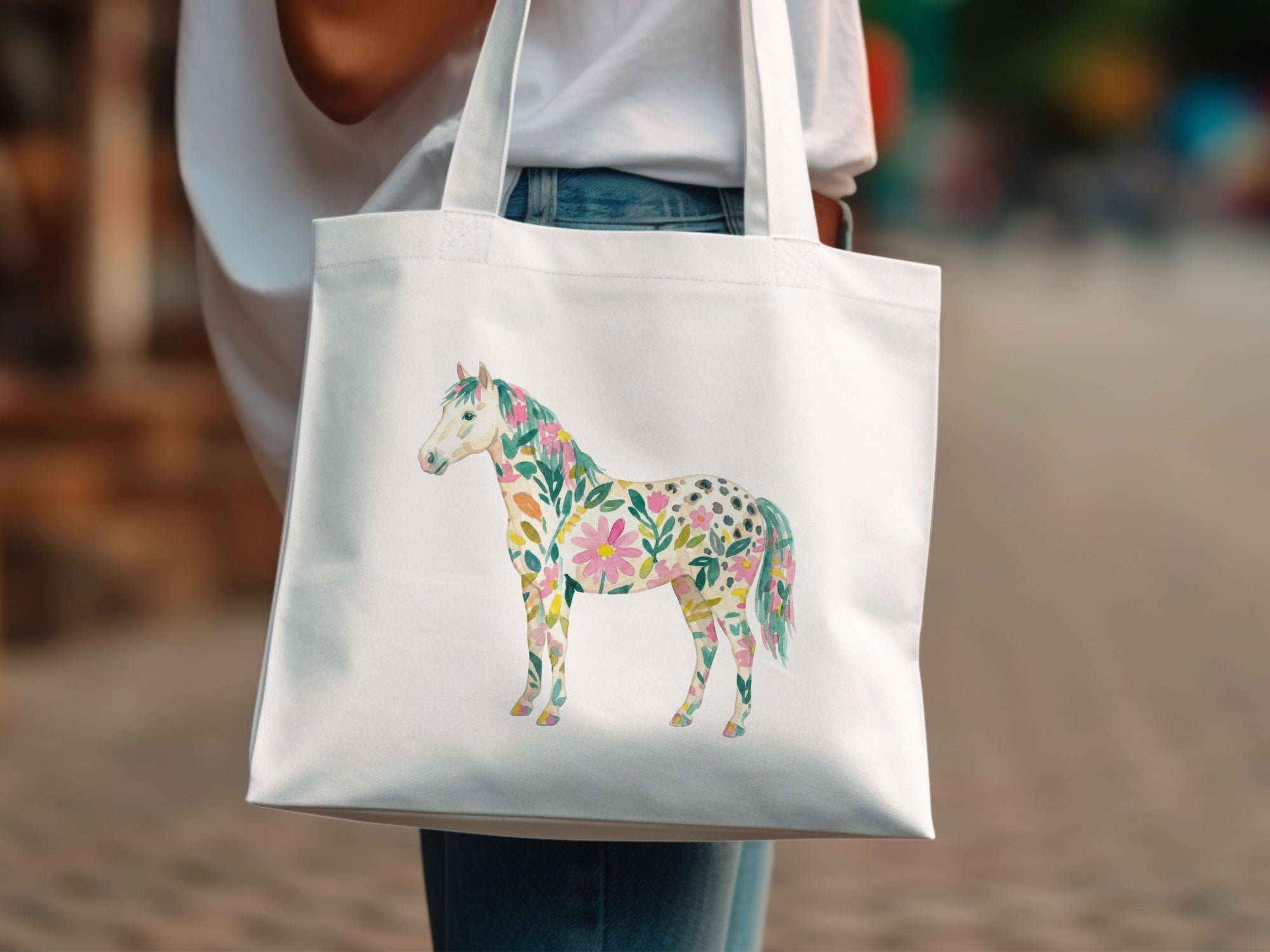 White tote bag with a watercolor horse illustration made of flowers.