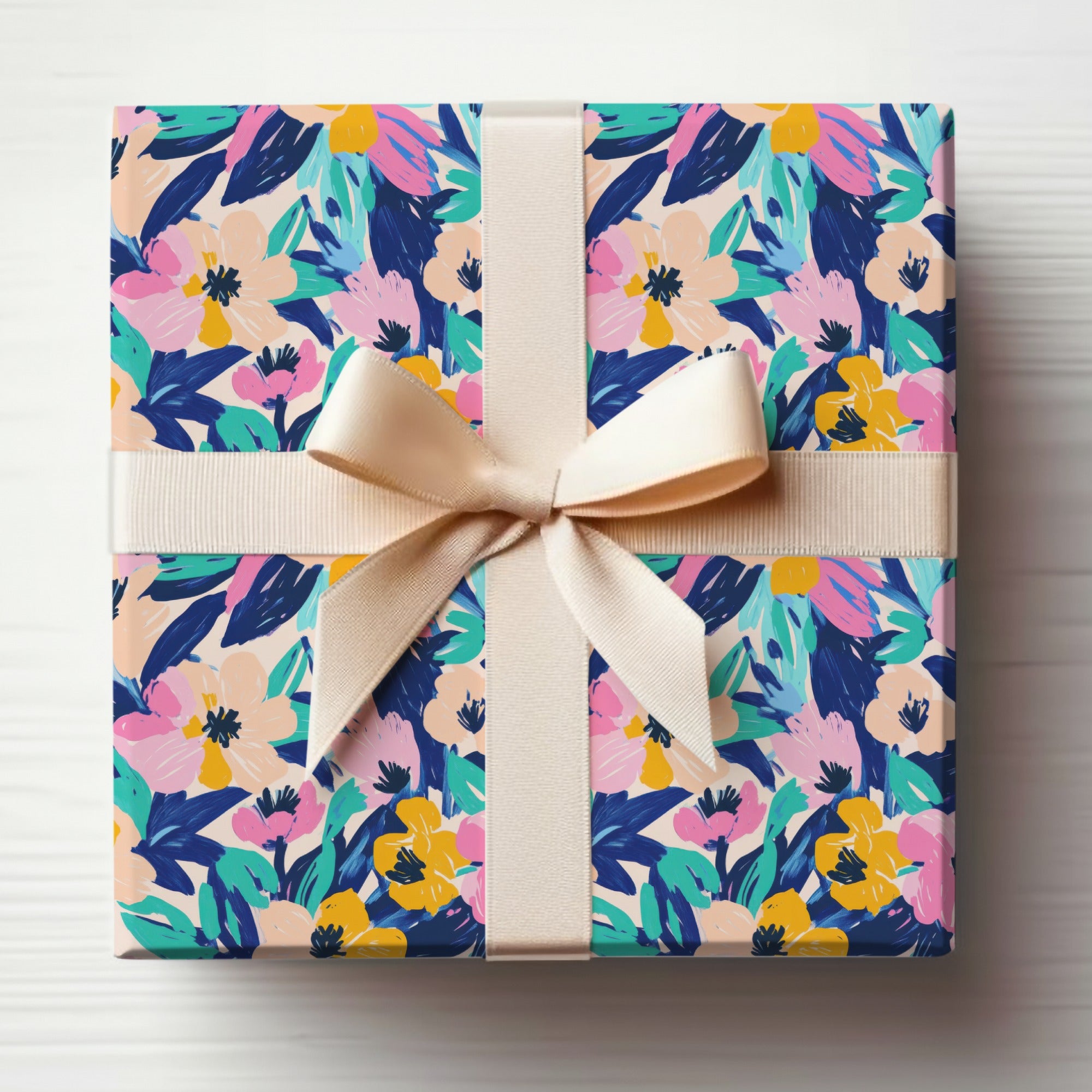 Gift box with a vibrant floral pattern tied with a cream ribbon.