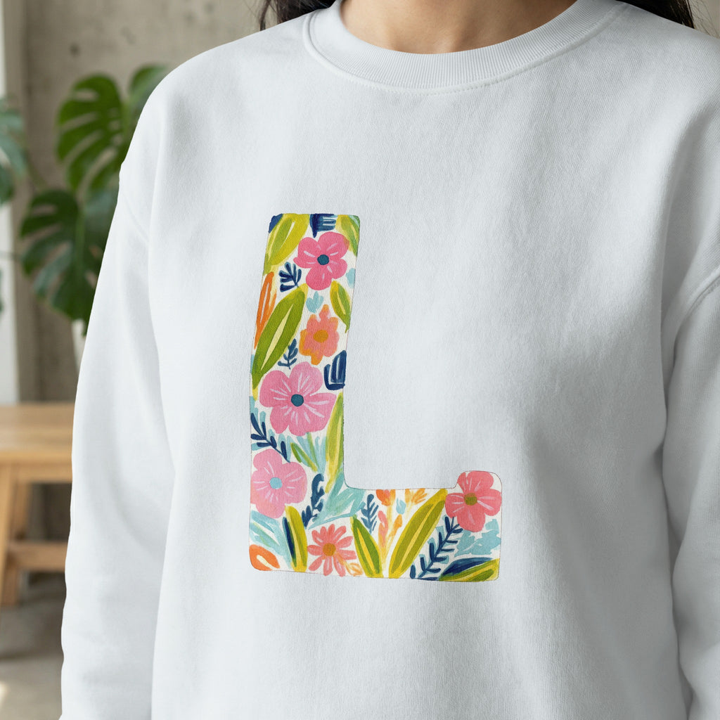 White sweatshirt with a large floral letter "L" design.
