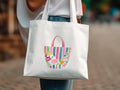 White tote bag with colorful floral and striped pattern.