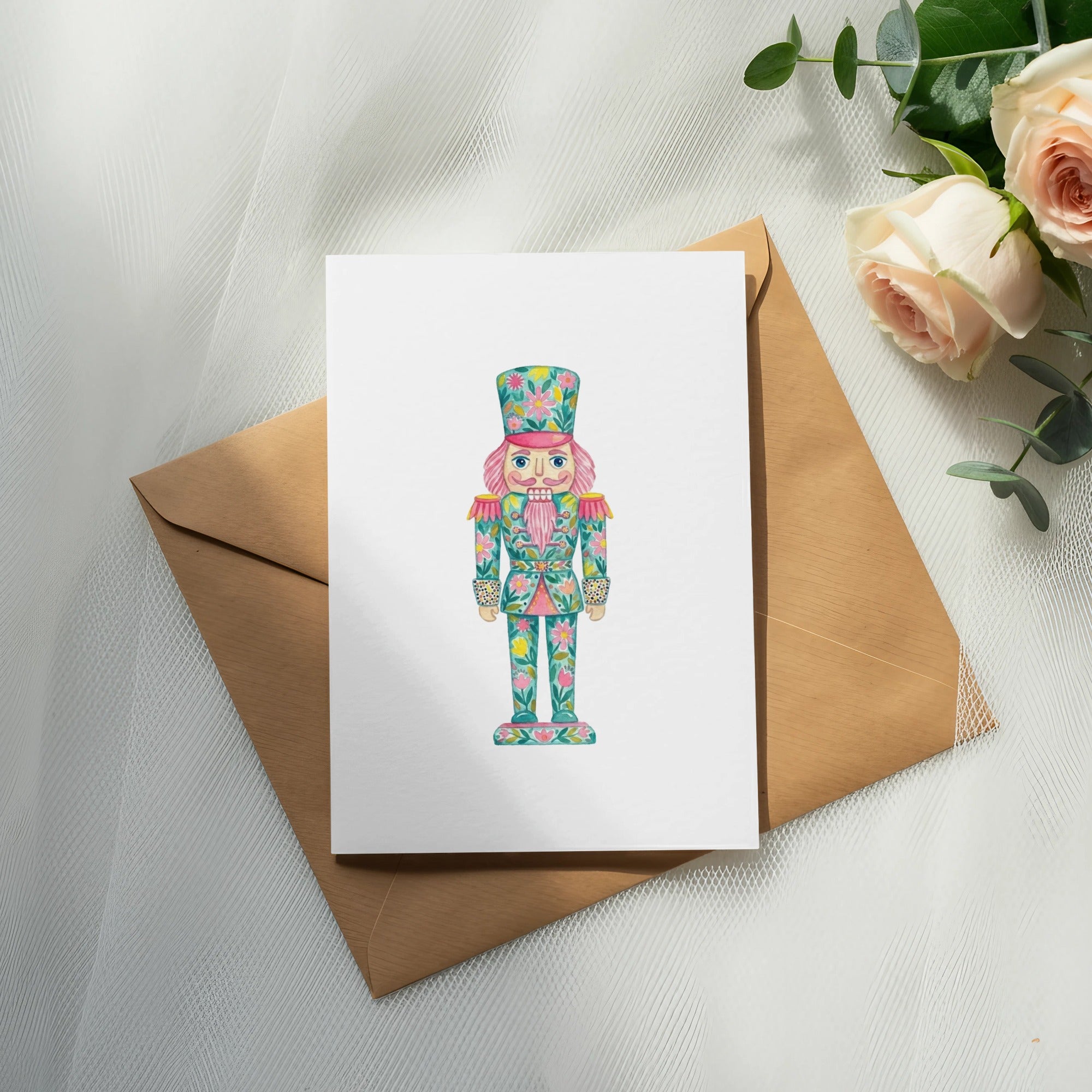 Nutcracker illustration on a white card with a brown envelope and roses.