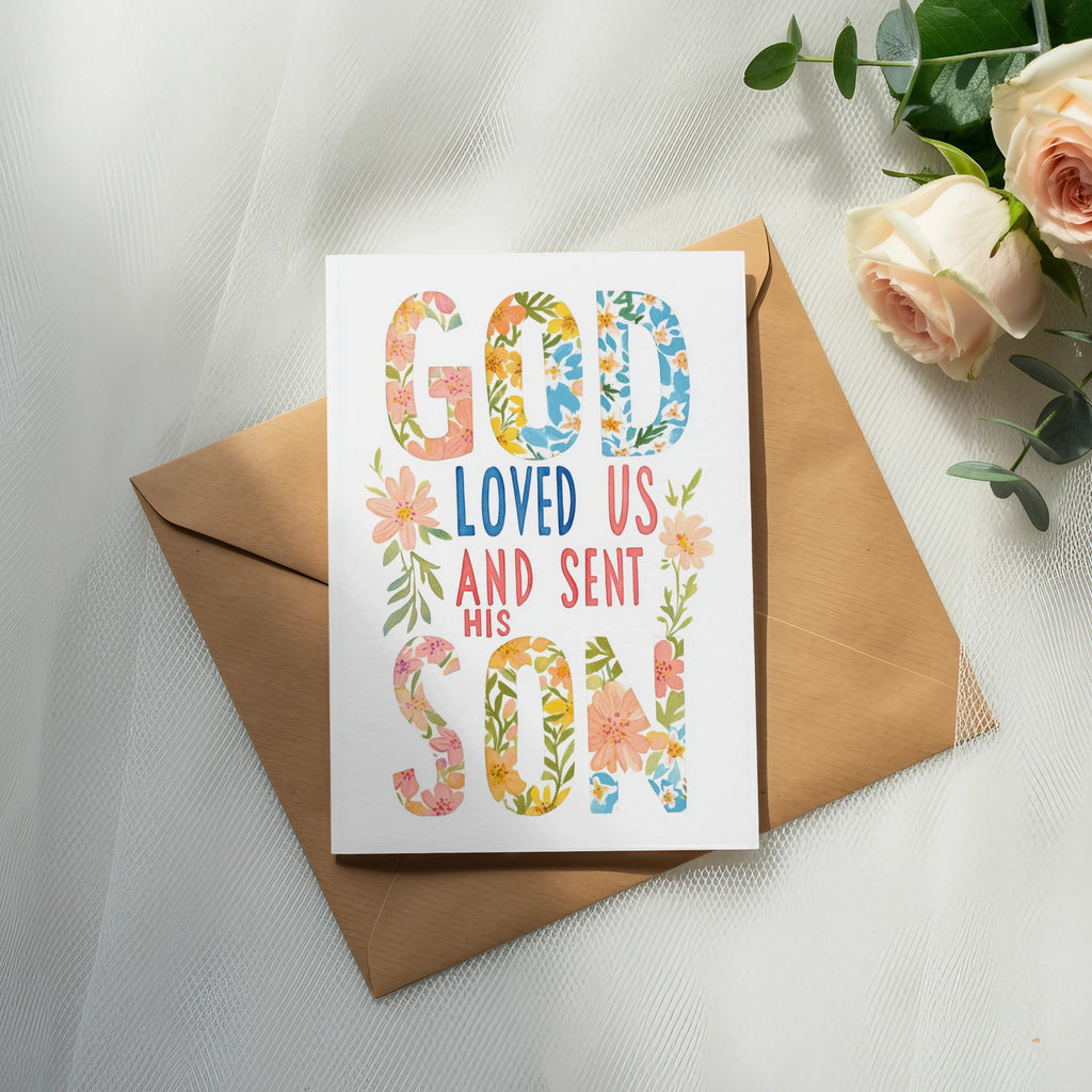 Card with floral text "God loved us and sent his Son" on an envelope.