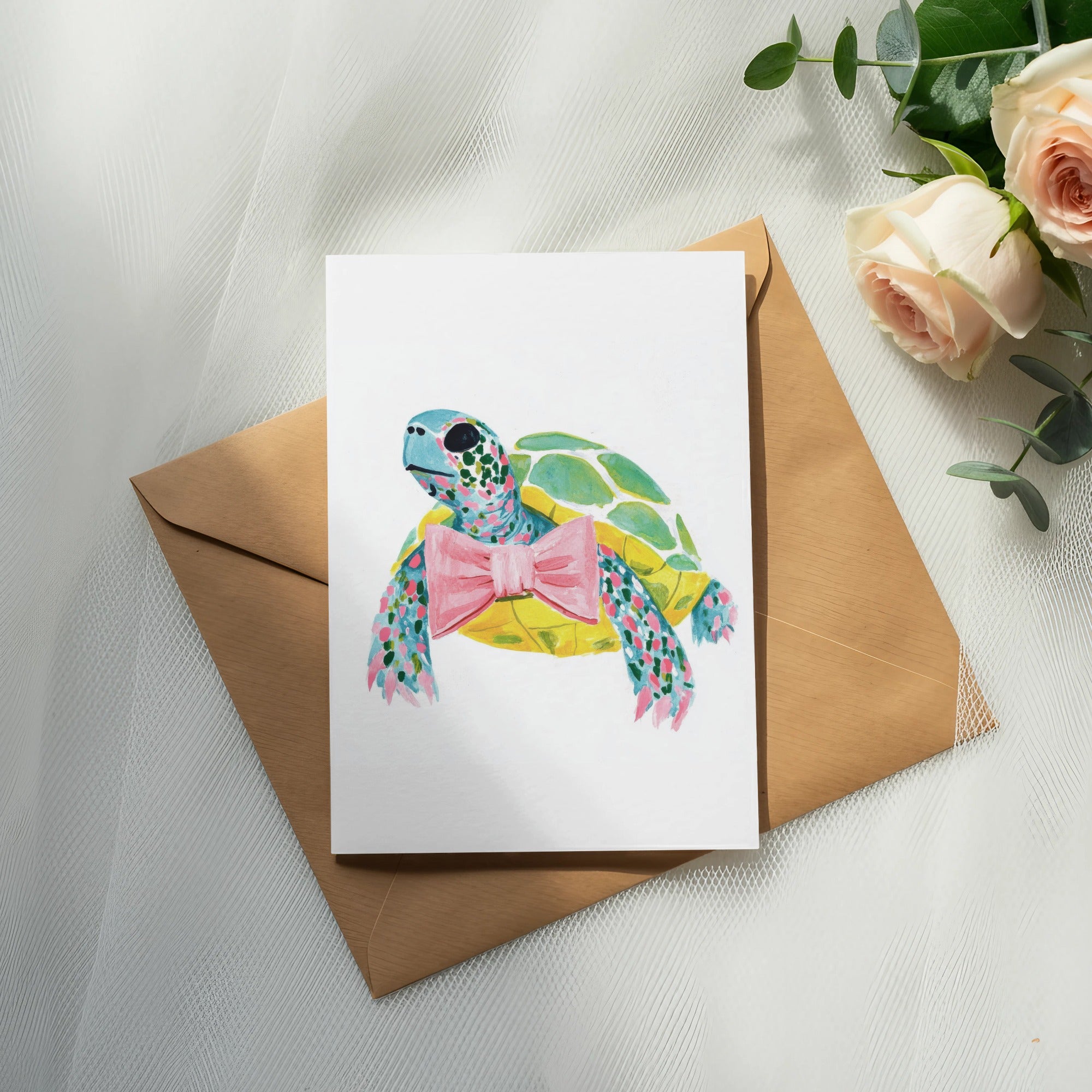 Watercolor turtle with pink bow on card, placed on brown envelope.