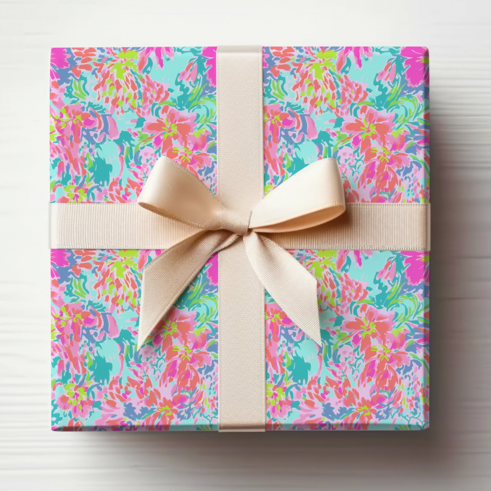 Gift box with a colorful floral pattern and a beige ribbon bow.