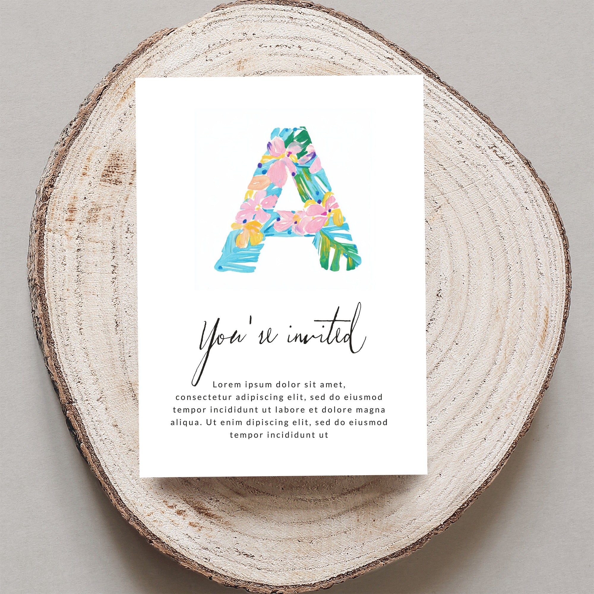 Floral letter A on invitation with "You're invited" text.