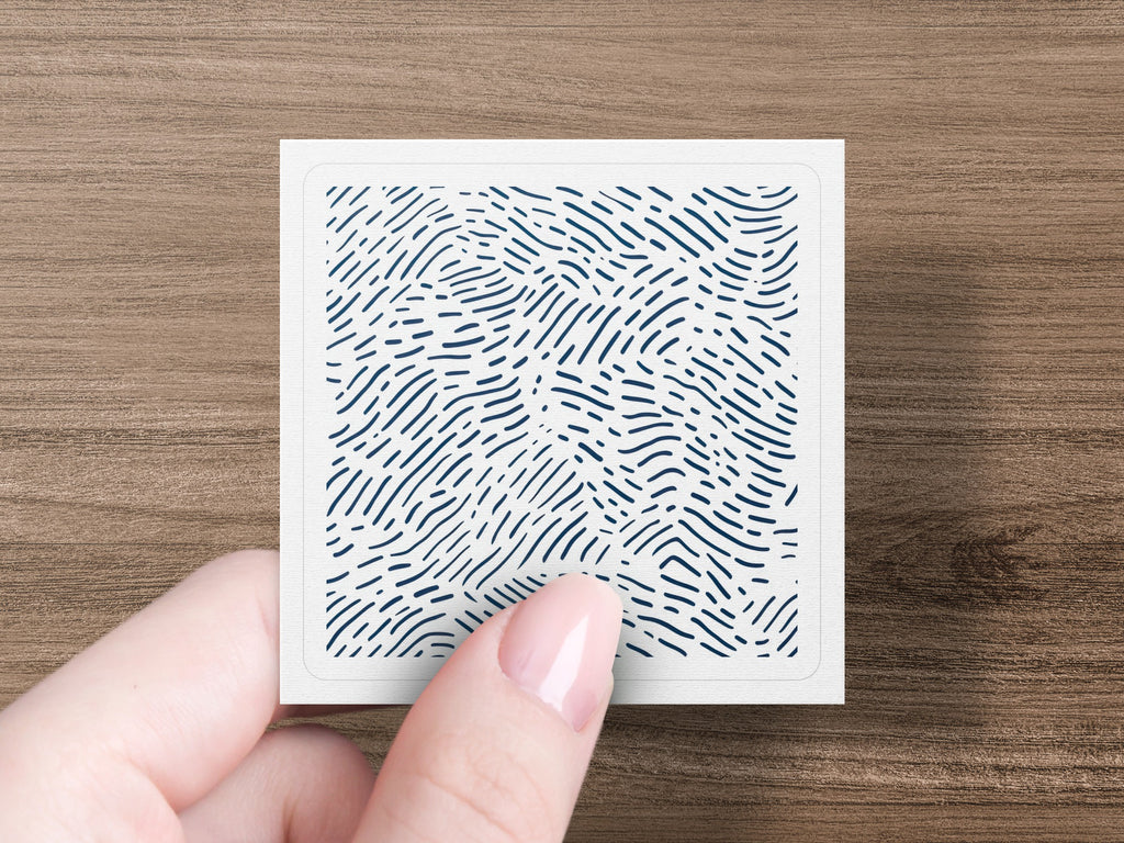 Hand holding a small square card with a blue wavy line pattern.