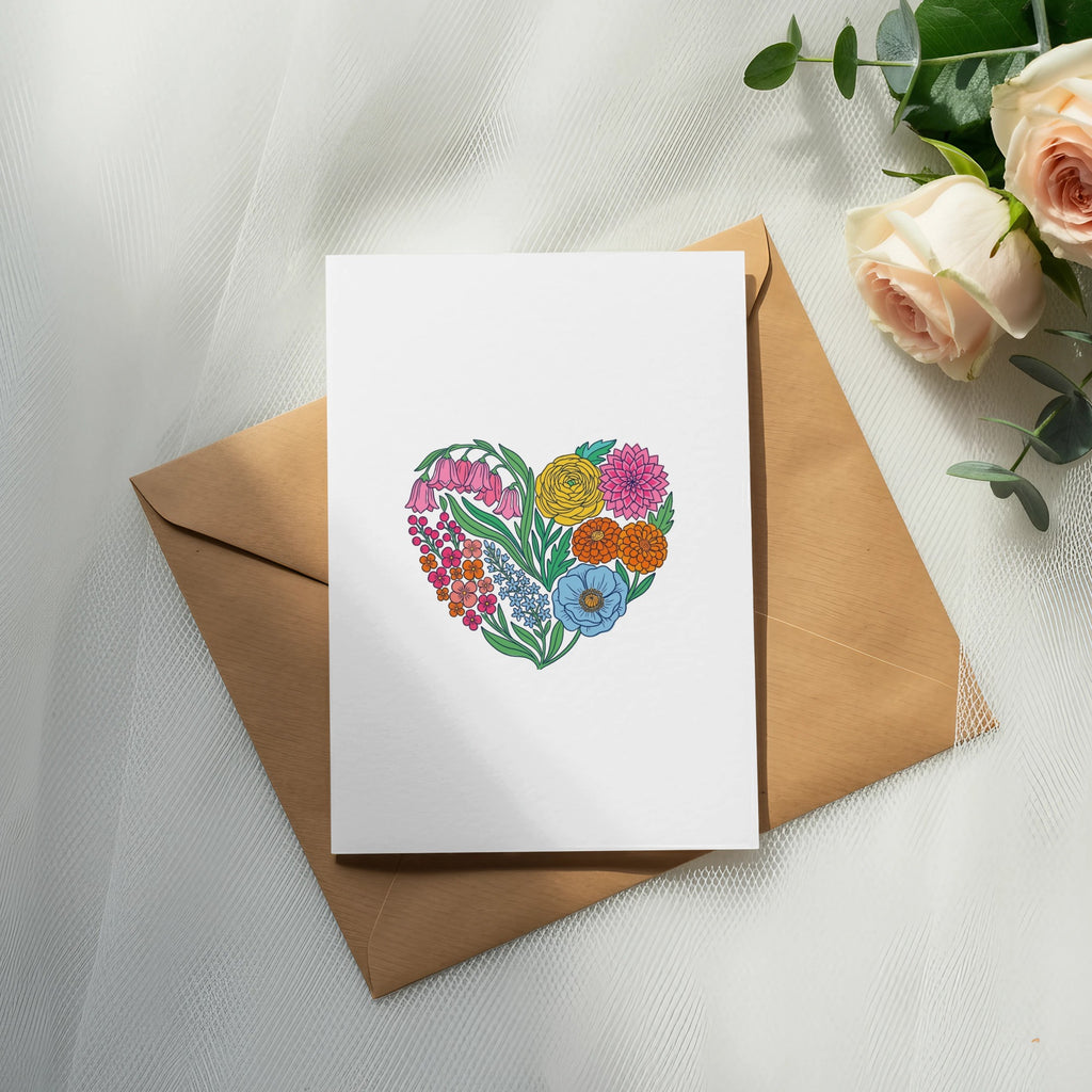 Card with floral heart illustration on brown envelope with roses and eucalyptus.