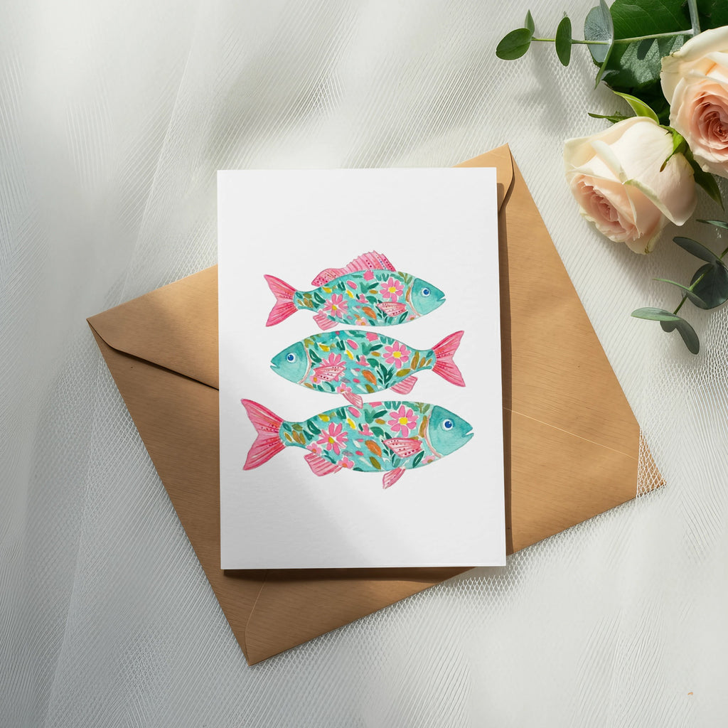 Card featuring three colorful, floral-patterned fish on brown paper.